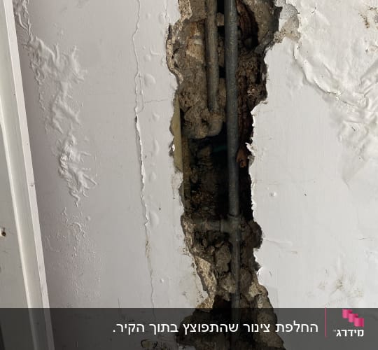 קיר עם חור וצינורות חשופים